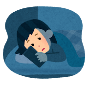 ベッドに入ってスマホを見る女性