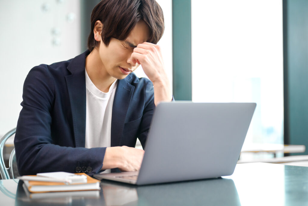 目元を抑える男性
